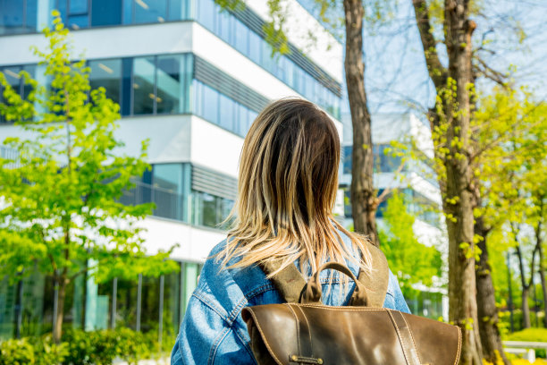 一个背着背包的年轻学生是第一次靠近大学校园。图片下载