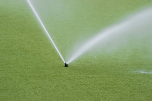 灌溉系统浇灌绿色草坪，用于足球比赛图片下载