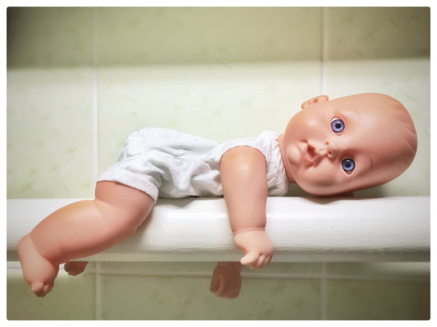 娃娃躺在水管上。图片下载