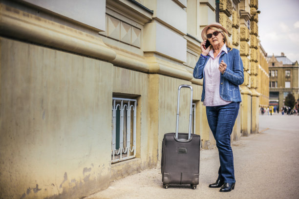 年长的女人带着旅行箱准备旅行图片下载