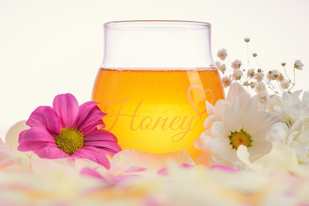 蜂蜜罐和花在白色的背景。芳香疗法和精油概念。图片下载