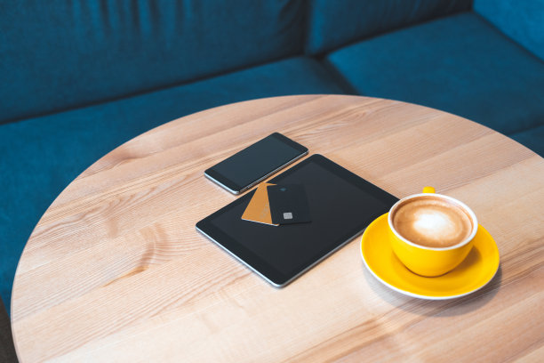高角度俯瞰或头顶，平板电脑和智能手机的平躺照片与信用卡躺在咖啡馆的木桌上舒适和现代的室内明亮的光线房间图片下载