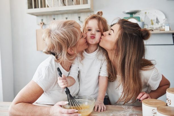 可爱的家庭。妈妈、奶奶和女儿在厨房里玩得很开心图片下载