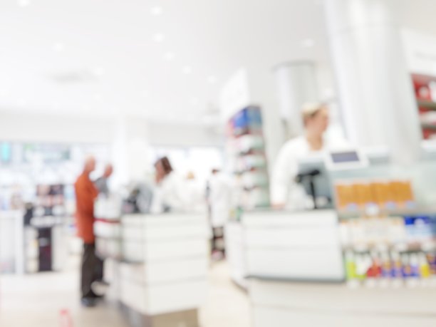 模糊抽象背景药房与客户。药店和药剂师视野模糊。模糊干净的药房与药品架上。散焦白色药店。图片下载