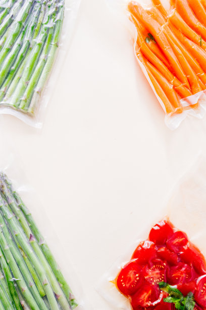 真空密封的蔬菜，胡萝卜，芦笋，西红柿，在灰色背景上俯视图，准备或用真空烹调机图片下载