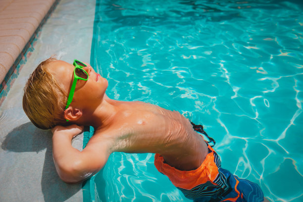 快乐可爱的男孩在游泳池放松，家庭度假图片下载