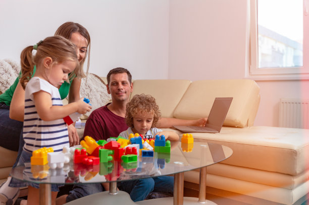 家庭时光：年轻父母和孩子玩积木玩具图片下载