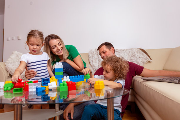 家庭时光：年轻父母和孩子玩积木玩具图片下载
