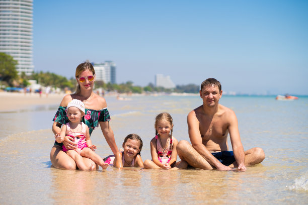 一个快乐的大家庭正在海滩上玩。海上大家庭的概念。海滩时尚图片下载