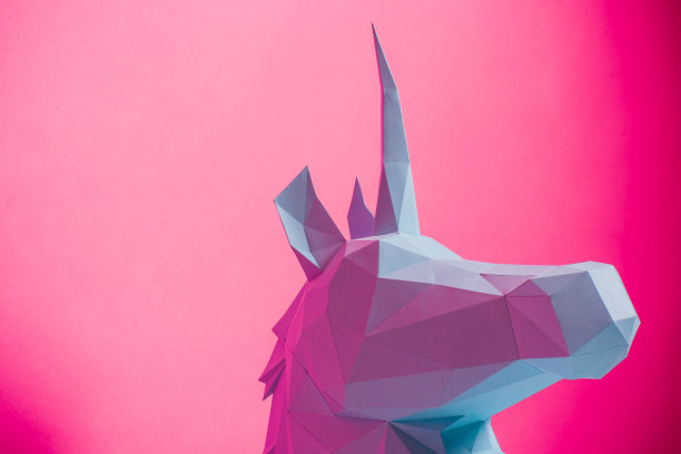3D纸独角兽在粉红色的背景左侧，水平。折纸玩具。折纸珀加索斯图片下载