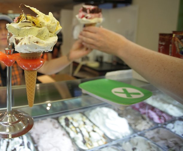 一位女士正在买一个蛋筒冰淇淋。夏季，商业和生活理念。图片下载