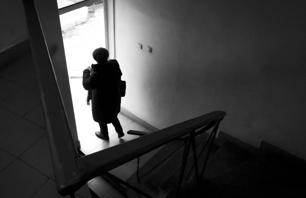 一名女子在街头摄影中走过一道门。图片下载