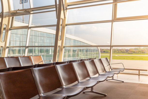 准备好飞行概念。现代化的国际机场出发区座椅排成一排，绿意盎然。图片下载
