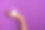 女人的手拿着白色的化妆品瓶在紫罗兰的背景。横幅。护肤，纯美，身体护理理念图片下载