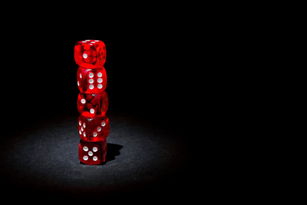 黑色背景下的红色骰子图片下载