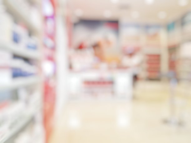 模糊抽象背景药房与客户。药店和药剂师视野模糊。模糊干净的药房与药品架上。散焦白色药店。图片下载