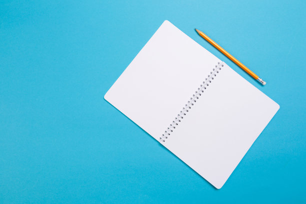 创意平面办公桌照片。顶视图办公桌与打开模拟笔记本和铅笔和植物在蓝色柔和的颜色背景。顶视图与复制空间，平铺摄影。——图片图片下载