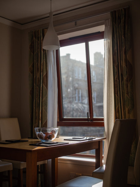 空餐桌的室内视图，透过窗户的柔和光线图片下载