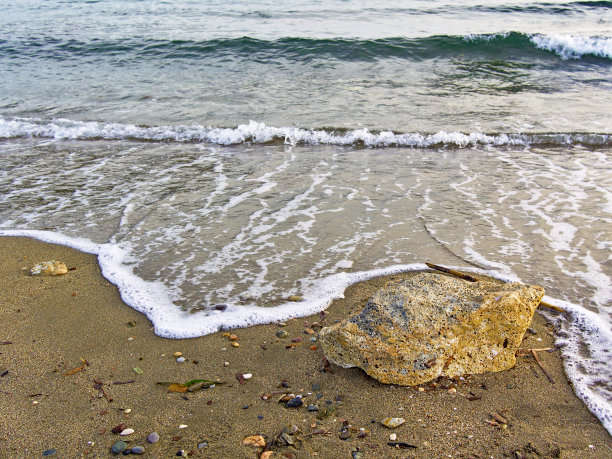 海浪到达沙滩和大石头。美丽的海岸细节，全景图像。图片下载