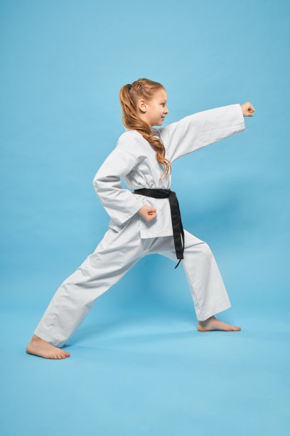 侧面的强女孩在和服站在空手道姿态图片下载