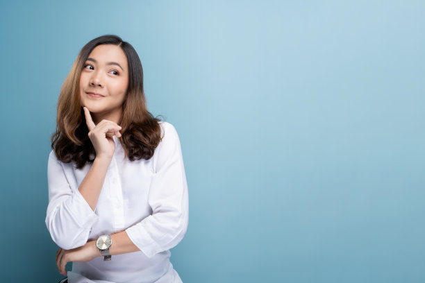 幸福的女人孤独地站在蓝色的背景下思考素材图片
