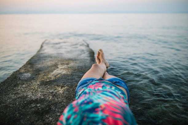 躺在海边码头上的女人的腿图片下载