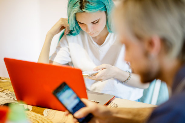 年轻女子在家里用笔记本电脑和智能手机工作图片下载