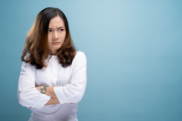 愤怒的女人孤立地站在蓝色背景下图片下载