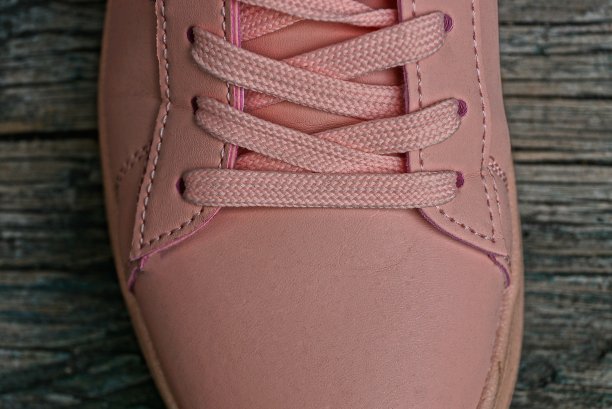 灰色的桌子上有拉绳的粉色皮靴图片下载