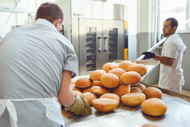 工厂工人把面包放在传送带上图片下载