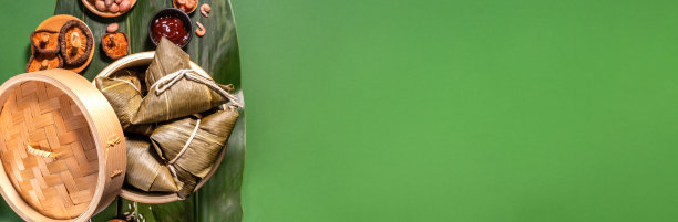 粽子、蒸熟的粽子以绿色的餐桌为背景，食物中有端午的概念，拉近，复制空间，俯视图，平铺图片下载