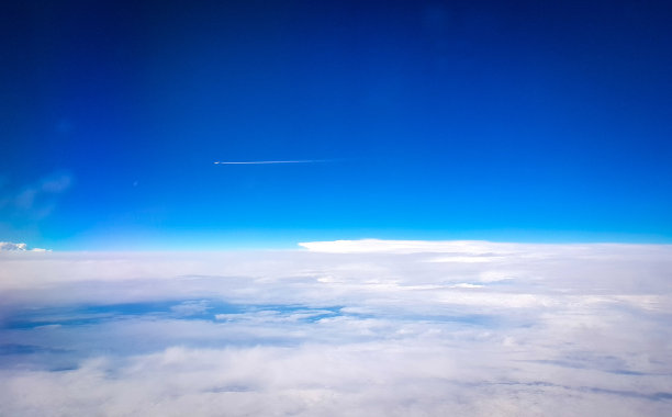 从飞机上俯瞰蓝天与另一架飞机的尾迹，在照片的下半部分，可以看到一片云海图片下载