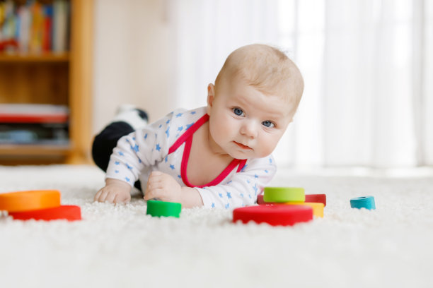 可爱的小女孩在玩五颜六色的木拨浪鼓玩具图片下载