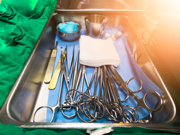 特写俯视图组敷料与无菌手术工具，夹钳，注射器，扩张器在医院手术托盘上的绿色布条上均为无菌套图片下载