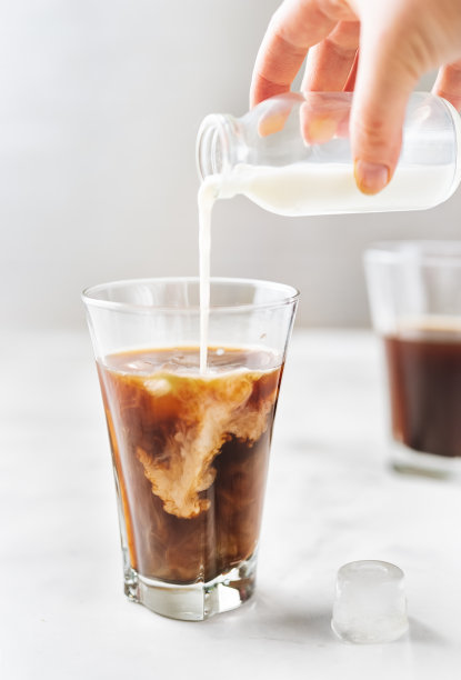 冰咖啡和倒牛奶的玻璃在白色的背景图片下载