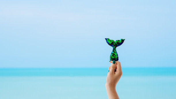 美人鱼亮片尾巴与蓝绿色海景背景图片下载