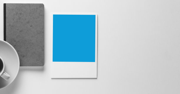 灰色皮革笔记本/书的白色背景孤立从上面与一个咖啡杯和一个空的蓝色宝丽来图片与文字空间，模型为业务。图片下载