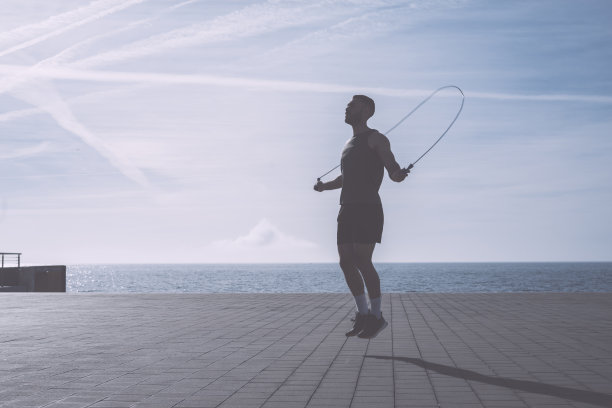 肌肉发达的年轻人在海边用跳绳锻炼图片下载