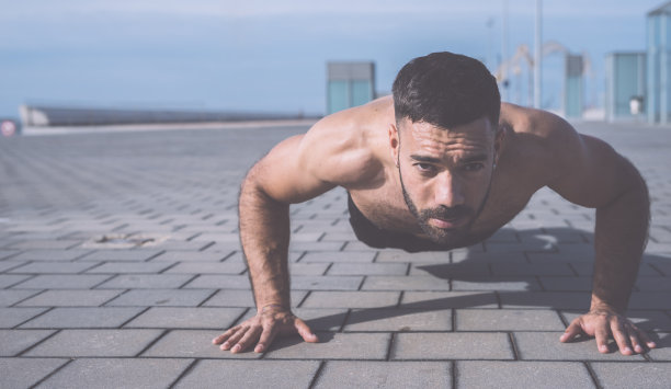 一个运动员在户外做俯卧撑的图片图片下载