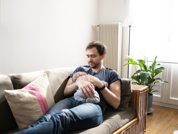 年轻的父亲快乐地抱着刚出生的儿子图片下载