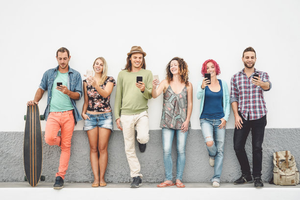 一群朋友在户外看他们的智能手机-年轻的千禧一代享受新技术智能手机和社交网络- z一代的概念，科技，青年的生活方式图片下载