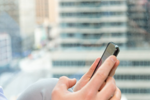 特写的智能手机与手在窗口和纽约市的观点图片下载