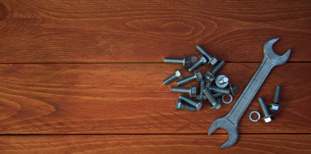 工具、扳手和螺母螺栓放在木制桌面上。图片与文字空间图片下载