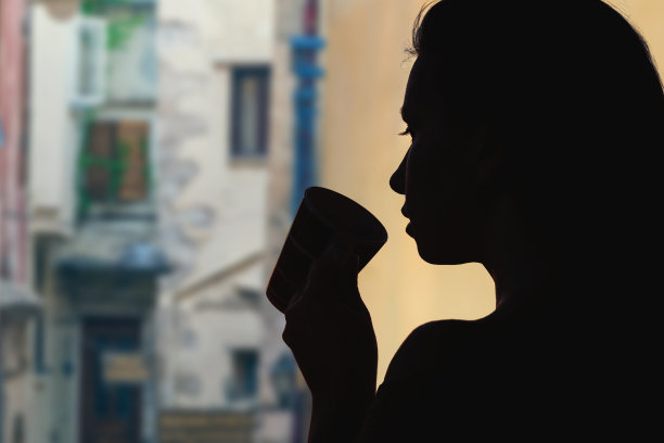 在维罗纳老城的一条狭窄的街道对面，喝着茶的女性。意大利图片下载