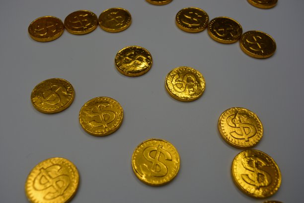 甜巧克力是以金币的形式出现的。漂亮的金丝溢流和金丝反光，具有古玩的风格。金融市场，有价值的硬币，黄金和纸币。图片下载