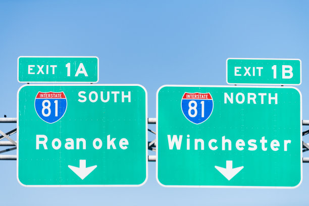 维吉尼亚州81号州际高速公路的1A和1B出口通往罗阿诺克和温彻斯特的绿色路标与蓝天隔绝图片下载