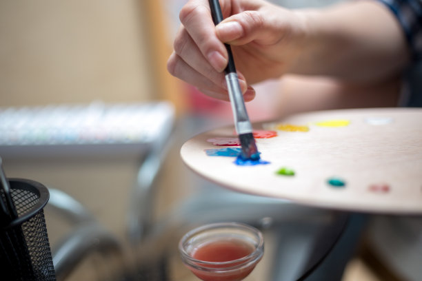 快乐的年轻女子在画布上作画图片下载