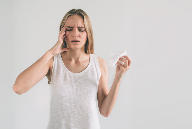 一个拿着手帕的年轻女子的画室照片。被隔离的病女孩流鼻涕。女模特正在为普通感冒做治疗。图片下载