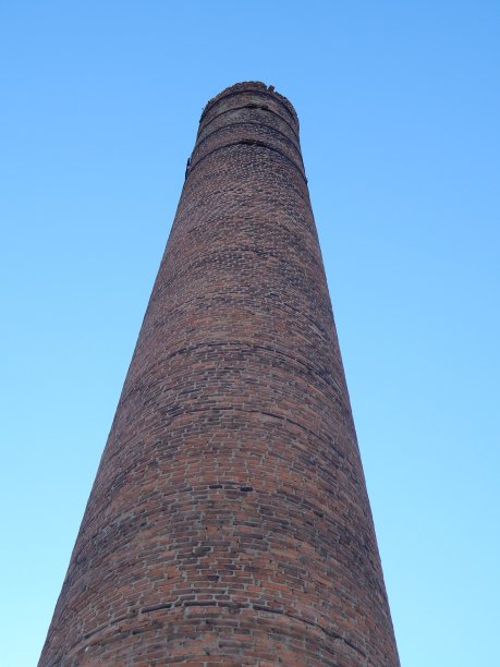 在蓝天背景下的工厂管道。高大的烟囱。照片图片下载