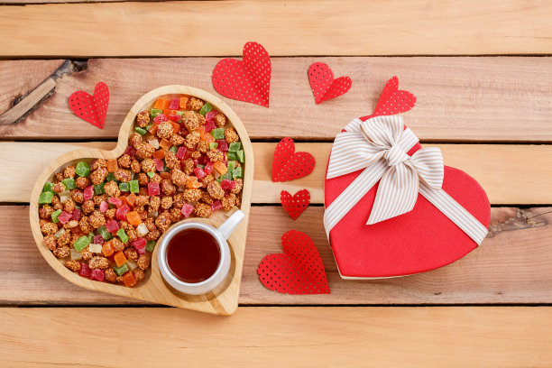 五颜六色的干果、茶和木制背景上的心形礼物图片下载